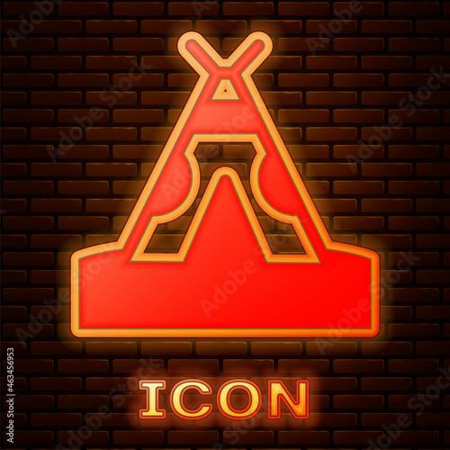 Glowing neon Traditional indian teepee or wigwam icon isolated on brick wall background. Indian tent. Vector