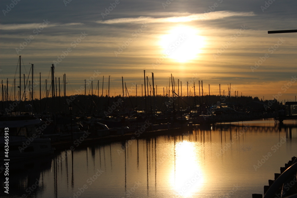Fototapeta premium Late afternoon sun reflects on water in a marina