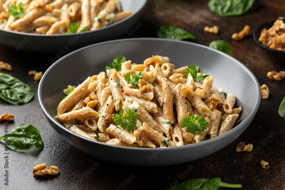 Whole Wheat Penne pasta with gorgonzola cheese sauce, spinach and walnut. Healthy food.