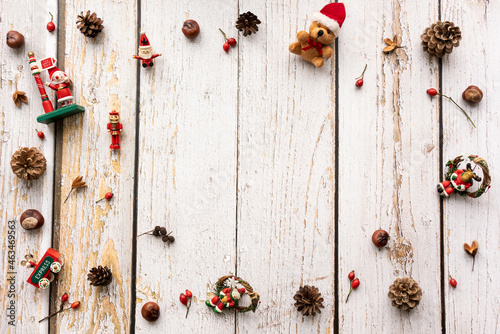 Christmas background with decoration like pine cones an christmas figures on a light, rustic wooden background in vintage style with space