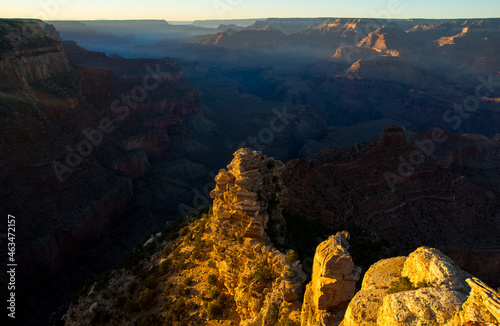 Warm light to the cliff upper the dark Grand Canyon. 