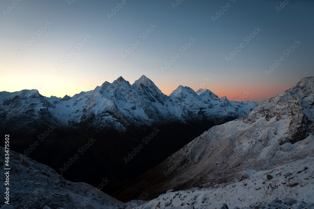 Snow-covered mountains and mountain peaks of Karachay-Cherkessia in winter at sunrise