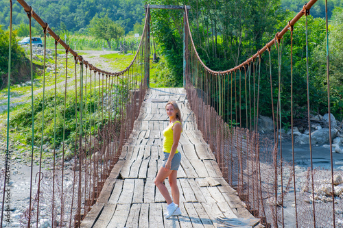 one girl stands on a suspension bridge in Georgia photo