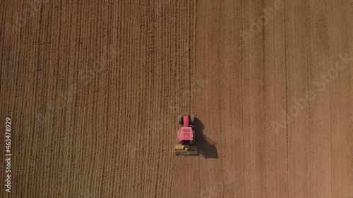 Aerial: Top Down View Of A Tractor Harrowing An Agriculture Field In Spring, Pukekohe, New Zealand photo