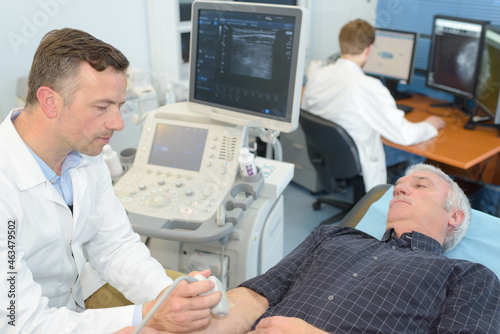 doctor performing ultrasound on male patients arm