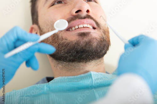 female dentist examining a male patient at clinic