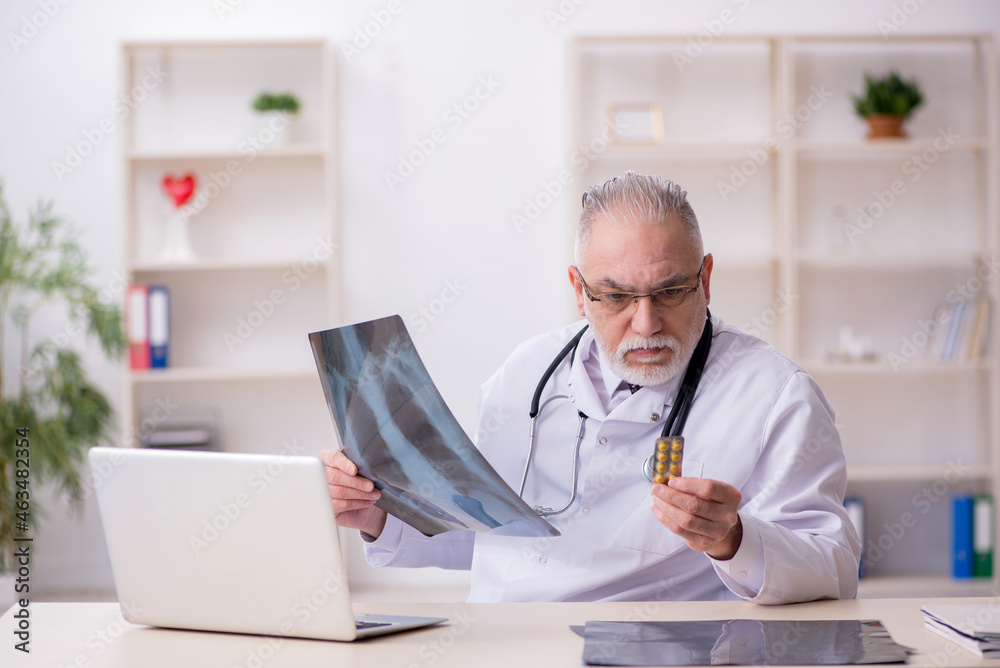 Old male doctor radiologist working in the clinic Old male doctor radiologist working in the clinic