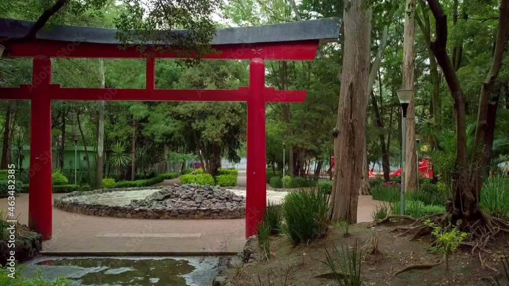 Traditional Japanese gate and rocky fountain surrounded by trees Traditional Japanese gate and rocky fountain surrounded by trees