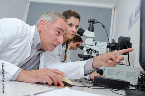 Teacher pointing to computer screen in laboratory