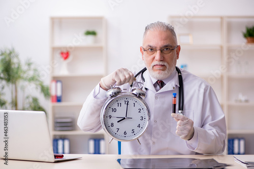 Photography Old male doctor in time management concept