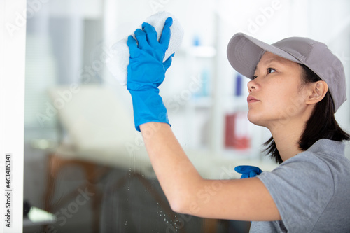 professional woman cleans glass window photo