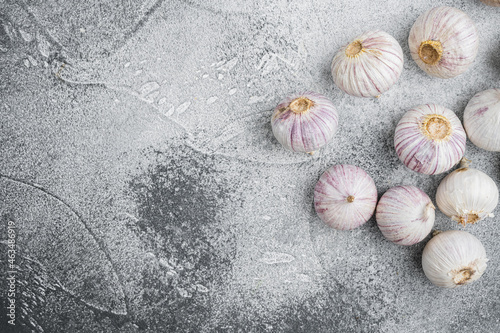 Small fresh garlic, on gray stone table background, top view flat lay, with copy space for text