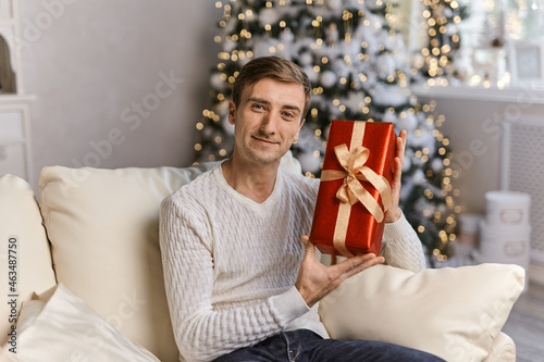 smiling Male wearing winter sweater with red gift box