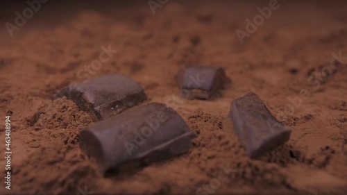 raw chocolate falling into cacoa powder slow motion photo