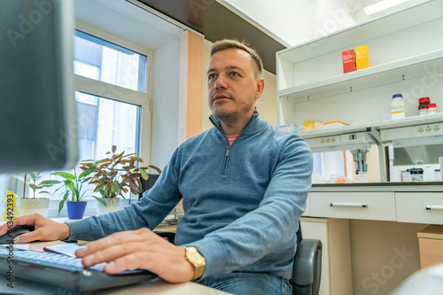 Photos Male scientist typing on his computer during research in laboratory
