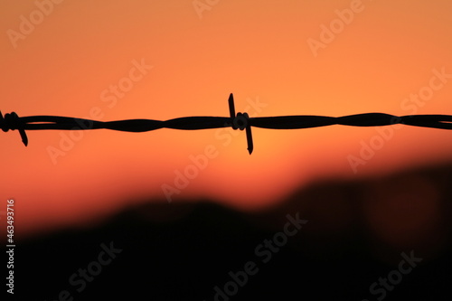 Barbwire silhouette at Sunset with a colorful sky north of Hutchinson Kansas USA.