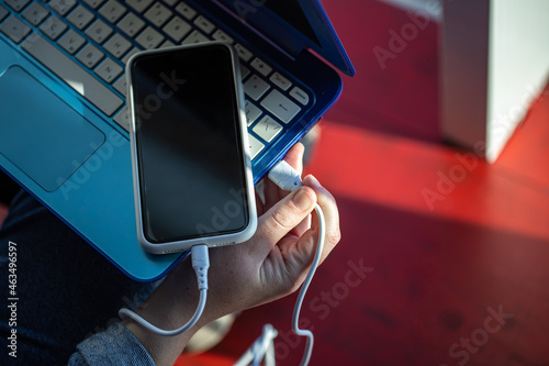 The smartphone is connected to the laptop via USB cable. photo