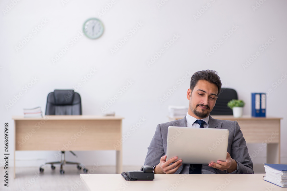 Young male employee working in the office Young male employee working in the office