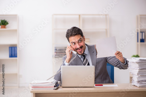 Young male employee unhappy with excessive work in the office