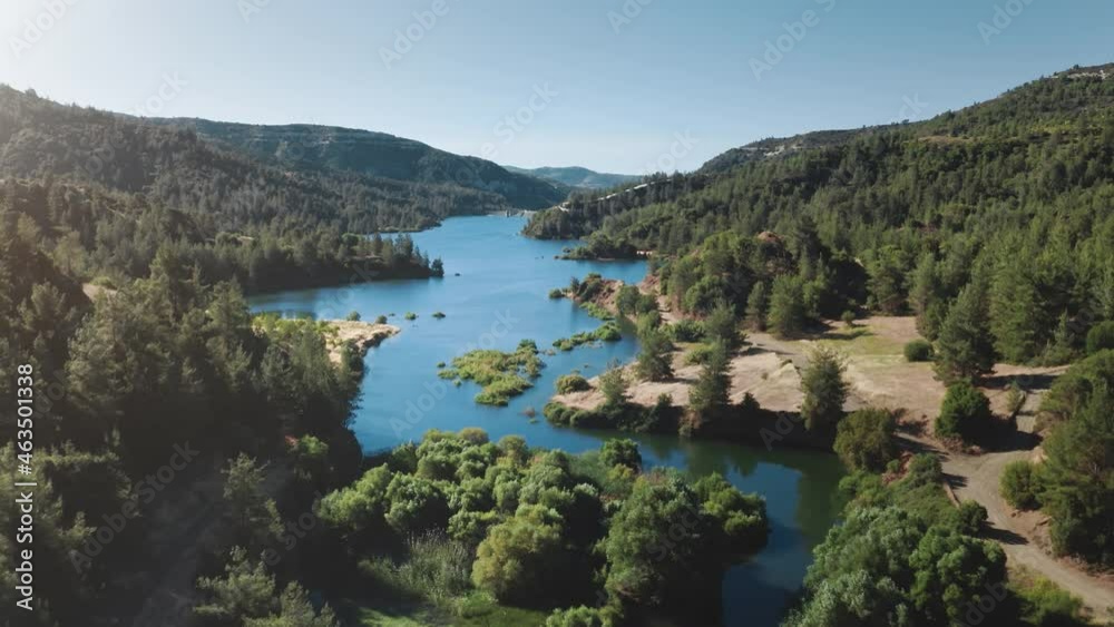 Alpine mountain lake landscape. Wild nature background. Blue water natural reservoir in highlands with green pine tree forest. Travel destination. Summer vacation, outdoor tourism. Aerial drone flight