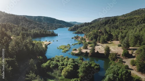 Alpine mountain lake landscape. Wild nature background. Blue water natural reservoir in highlands with green pine tree forest. Travel destination. Summer vacation, outdoor tourism. Aerial drone flight