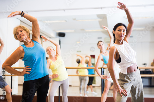 Fototapeta Naklejka Na Ścianę i Meble -  Dancing active women engaged in a group class practice energetic dance in a modern dance studio