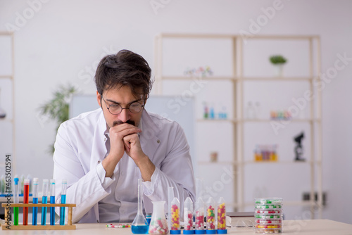 Young male chemist in drugs synthesis concept