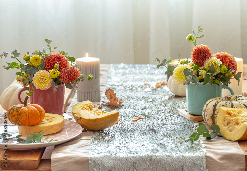 Festive table setting with pumpkins and chrysanthemum flowers.