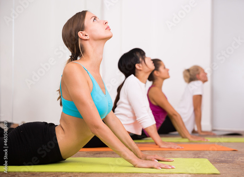 Women pull their backs on yoga training in the studio. High quality photo