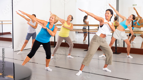 Positive women practicing vigorous dance movements in group dance class