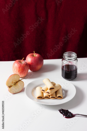 Apple filled biscuits and a jar of blueberry jam. Blueberry jam on a spoon.