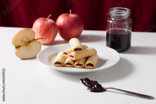 Apple filled biscuits and a jar of blueberry jam. Blueberry jam on a spoon.