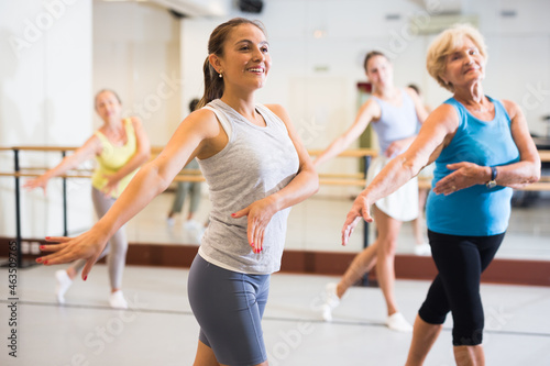 Portrait of an active latin american woman enjoying energetic dancing in a female group in a modern dance studio