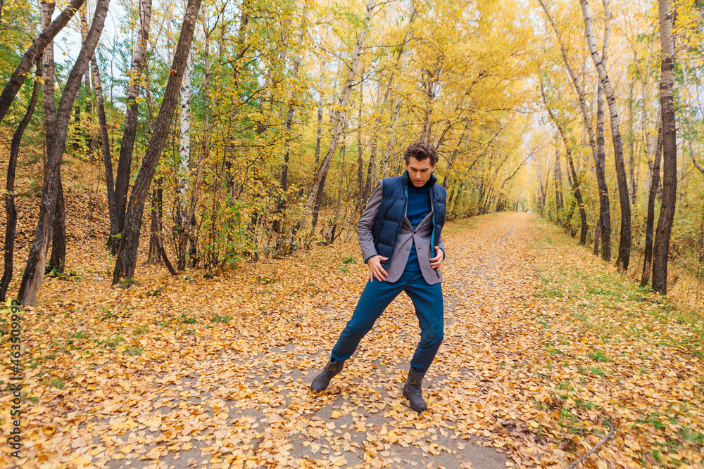 Tall handsome man walking in the autumn alley Tall handsome man walking in the autumn alley