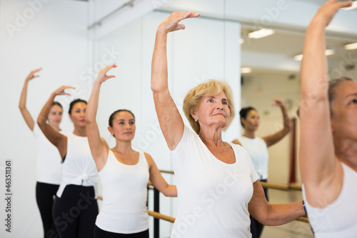 Various aged women dancing ballet during their group training.