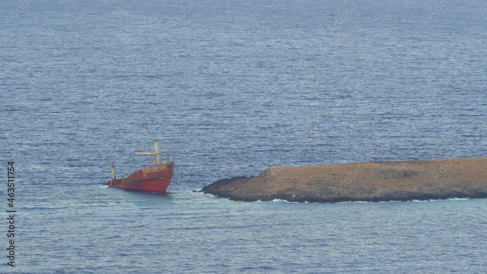 Still shot of a cargo ship wreck accident in shallow ocean water