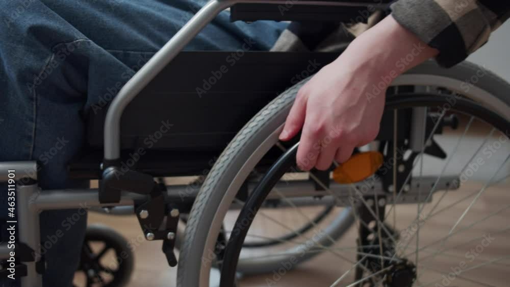 A disabled man is riding on the wheelchair through the room A disabled man is riding on the wheelchair through the room