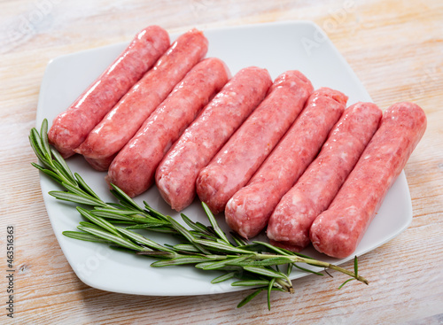 Traditional Catalan raw pork sausage botifarra ready for grilling on wooden board..