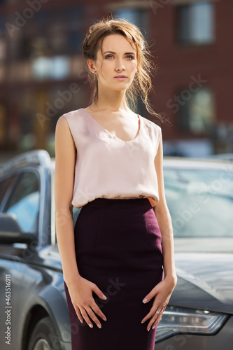 Young fashion woman in pink sleeveless blouse and pencil skirt
