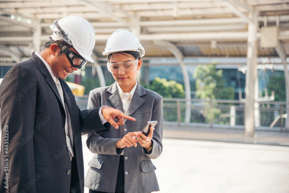 Civil engineer teams meeting working together wear worker helmets hardhat on construction site in modern city. Foreman industry project manager engineer teamwork. Asian industry professional team
