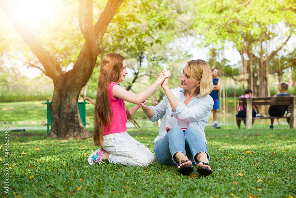 Obraz premium Mother and her daughter playing in the garden in summer day, family concept