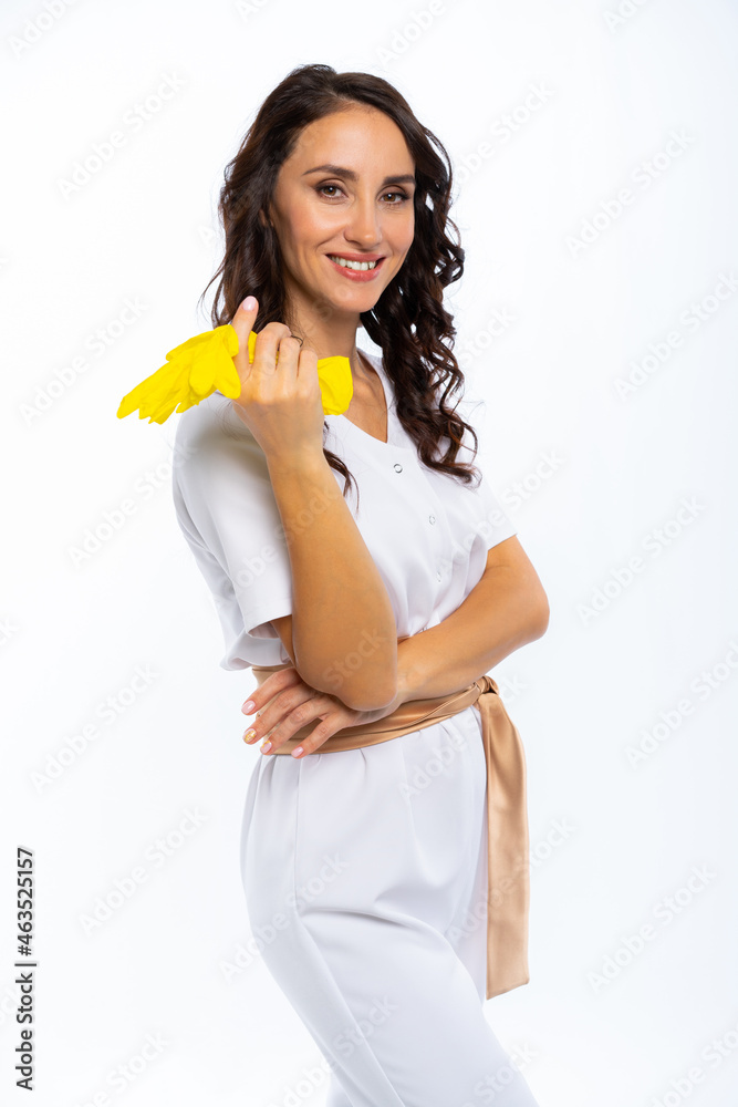 female specialist is ready to work. a master in a white overalls with a gold belt holds yellow gloves. certified specialist. isolated white background female specialist is ready to work. a master in a white overalls with a gold belt holds yellow gloves. certified specialist. isolated white background
