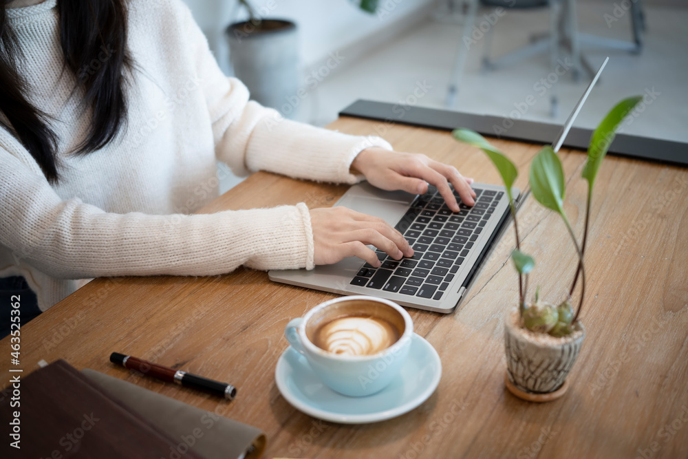 Cropped shot young female in white sweater working with computer laptop. Cropped shot young female in white sweater working with computer laptop.
