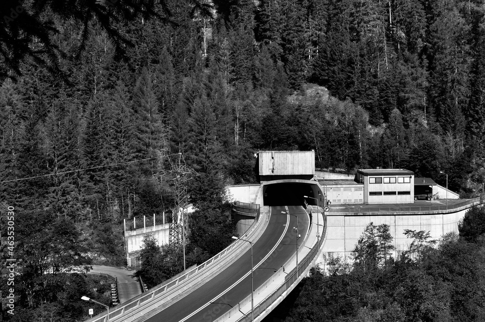 Fototapeta premium Road on a bridge with access in a tunnel and a road under the bridge. Black and white image.