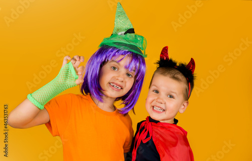 Funny child in a carnival costume for Halloween is isolated on a yellow background. Traditions, holidays concept.