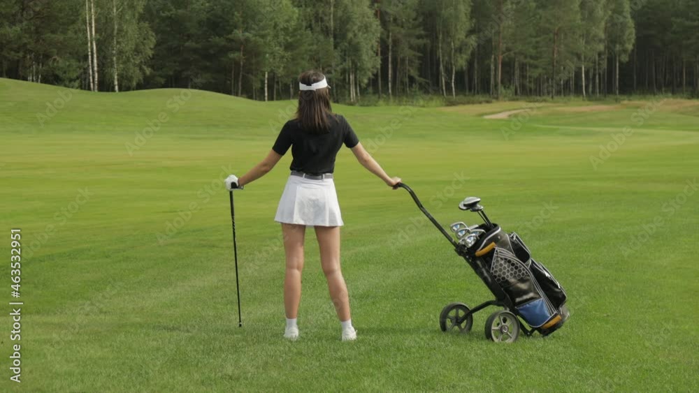 Young woman on golf course, back view. Young woman on golf course, back view.