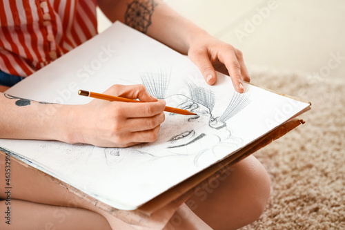 Young female artist drawing in workshop, closeup