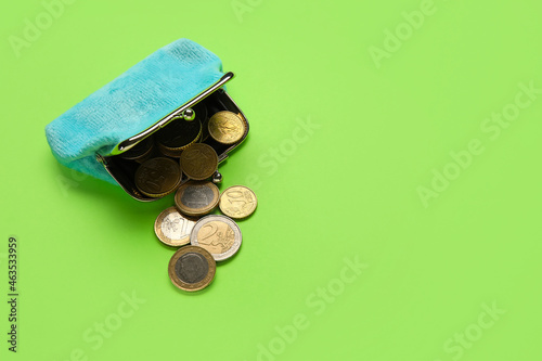 Blue wallet with coins on green background