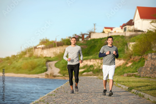 Sporty young men running ne...