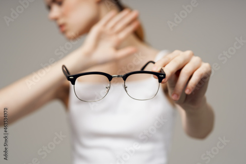 disgruntled woman glasses in the hands of astigmatism light background